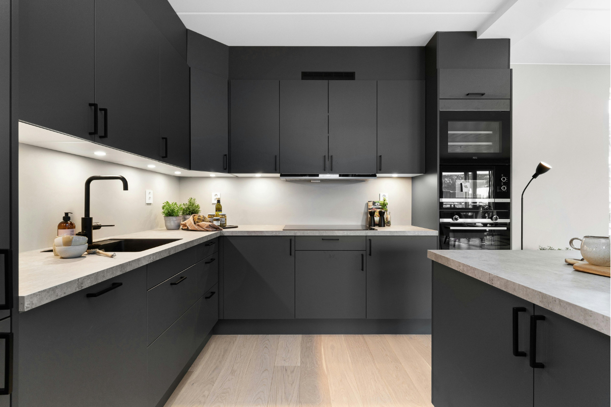 L-shaped modular kitchen with white acrylic finish, handleless design, and quartz countertop