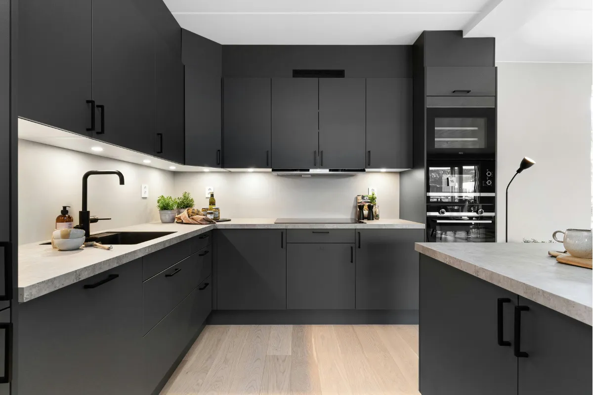 L-shaped modular kitchen with white acrylic finish, handleless design, and quartz countertop
