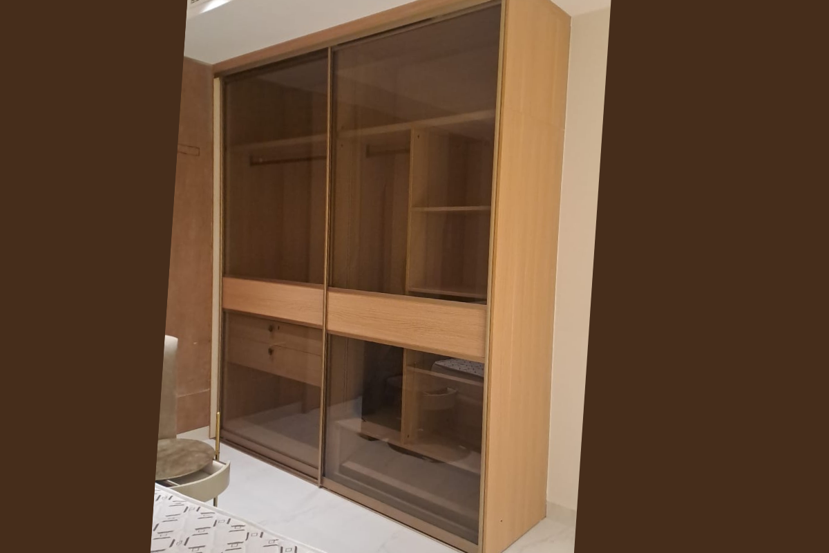 Full-height sliding wardrobe with mirror doors and internal organizers in a master bedroom.