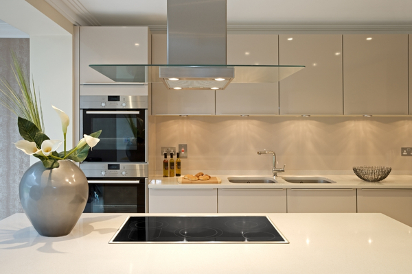 Modern L-shaped modular kitchen with white acrylic finish and wooden countertop by Wudiqa