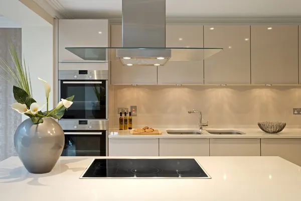 Modern L-shaped modular kitchen with white acrylic finish and wooden countertop by Wudiqa